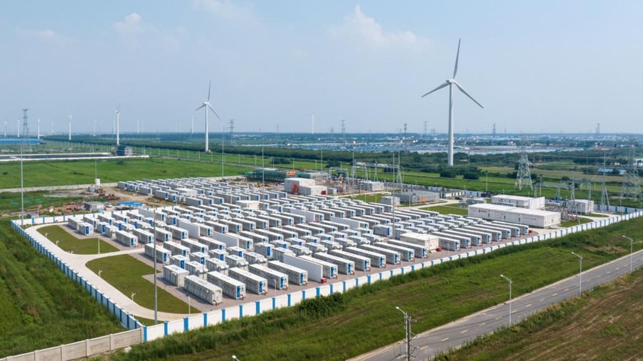 俯视图:大型工业建筑旁边的风电场,乡村风景中的很多风力发电机