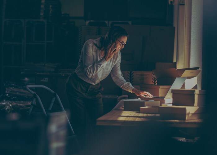 Female talking over phone while working on a desk