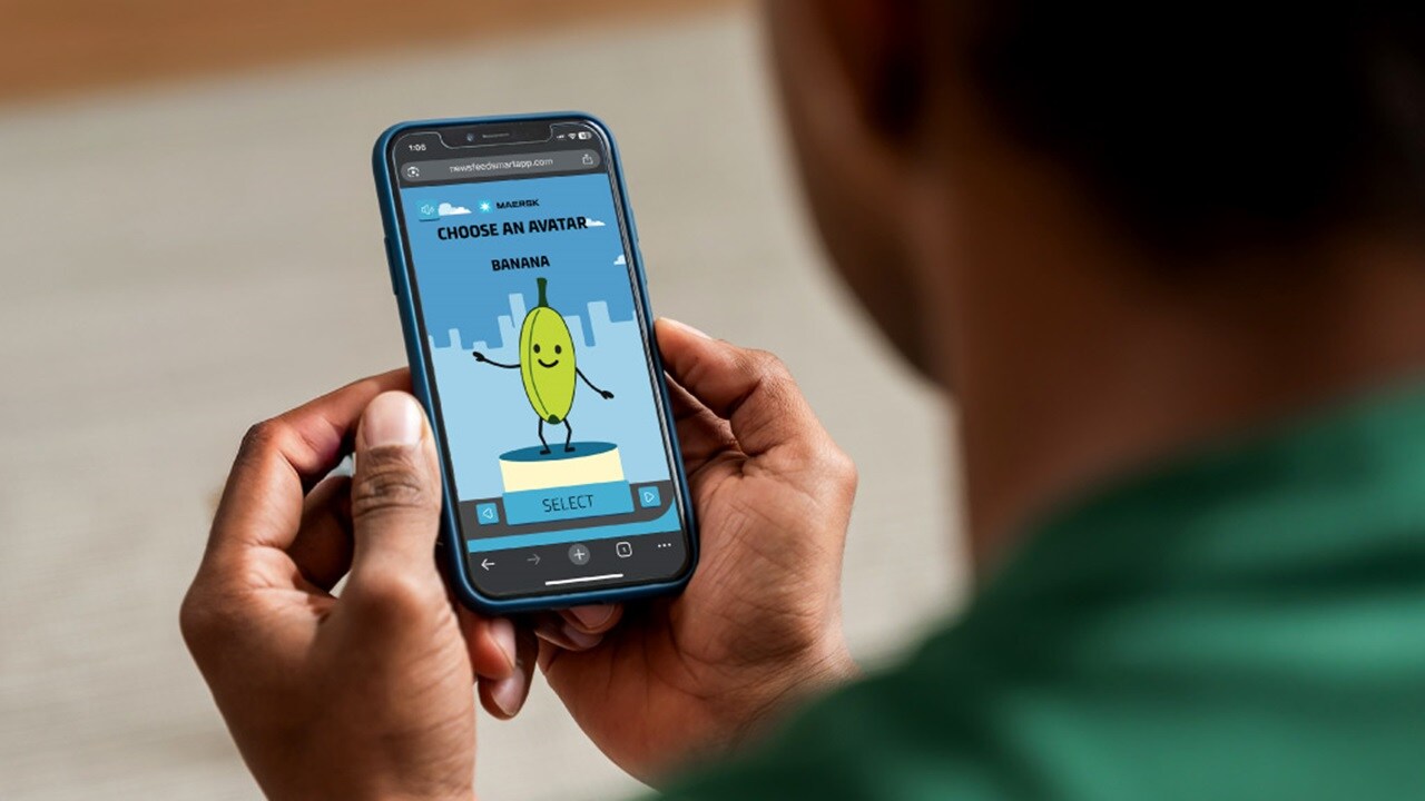 A man focused on playing a game on his smartphone, sitting comfortably in a casual setting.