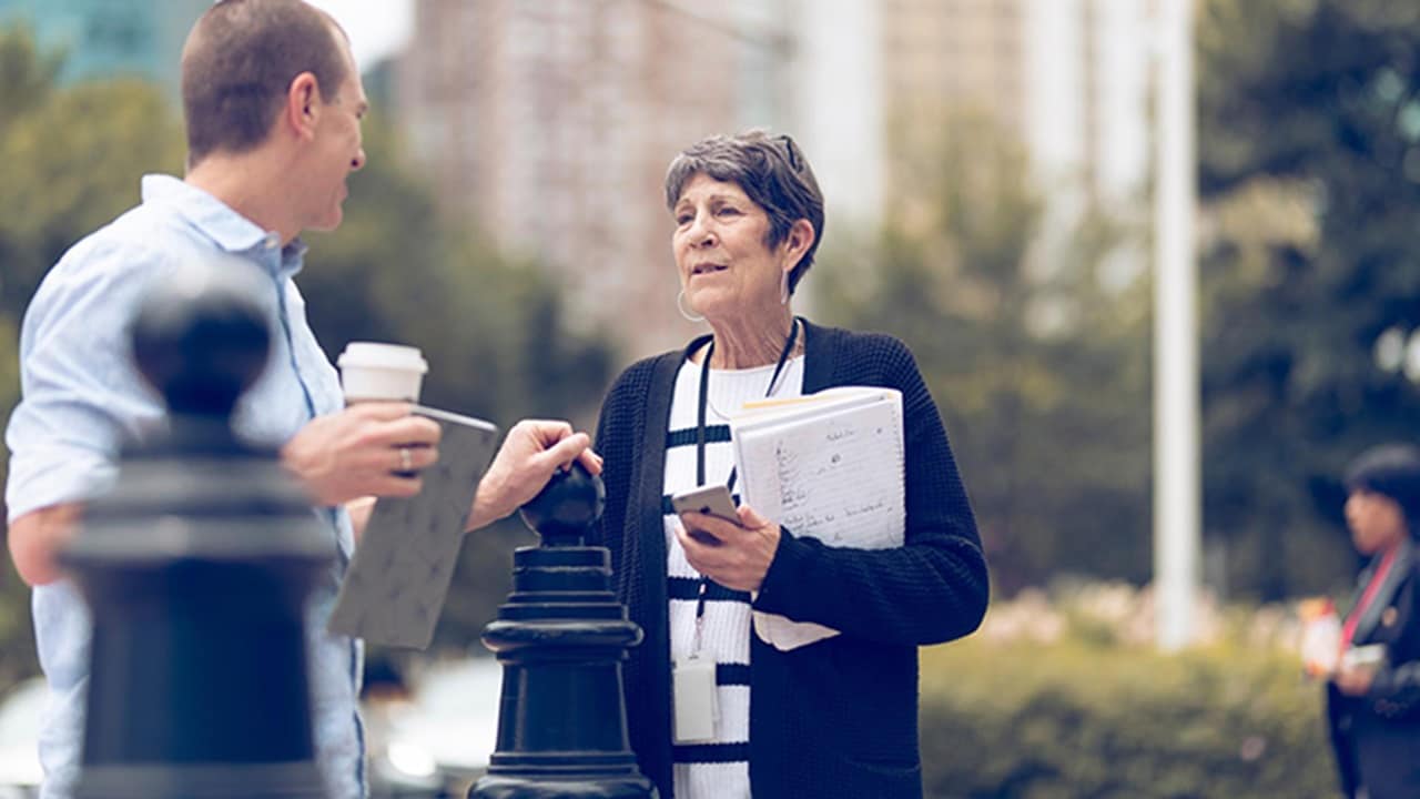An elderly woman converses with a middle-aged man.