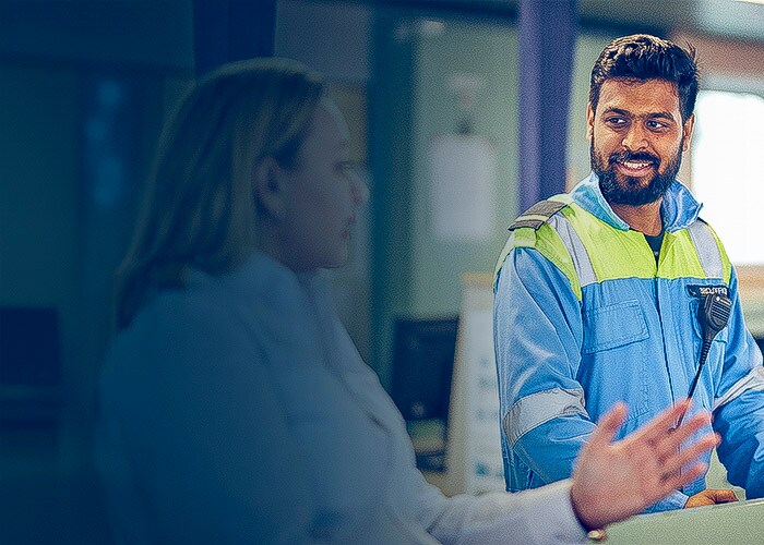 A man in a safety vest talking to a woman