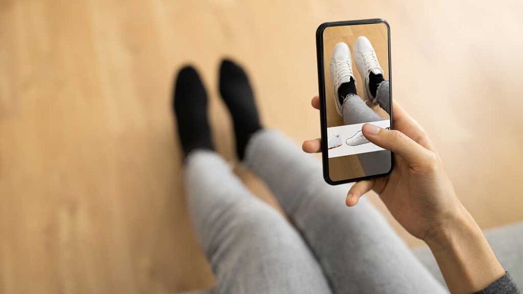 woman trying on shoes with virtual technology