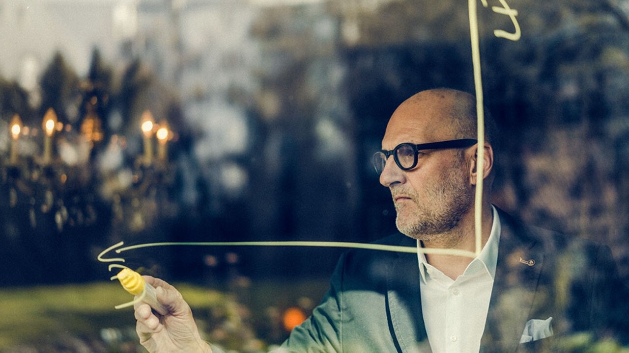 Employee in a suit drawing a graph on glass