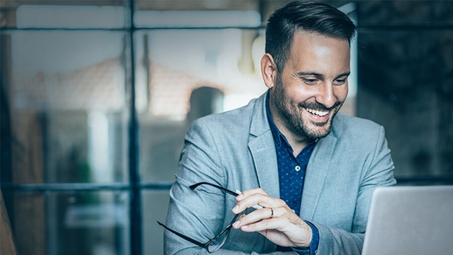Customised FMCG logistics solutions – A happy man looking at their laptop.
