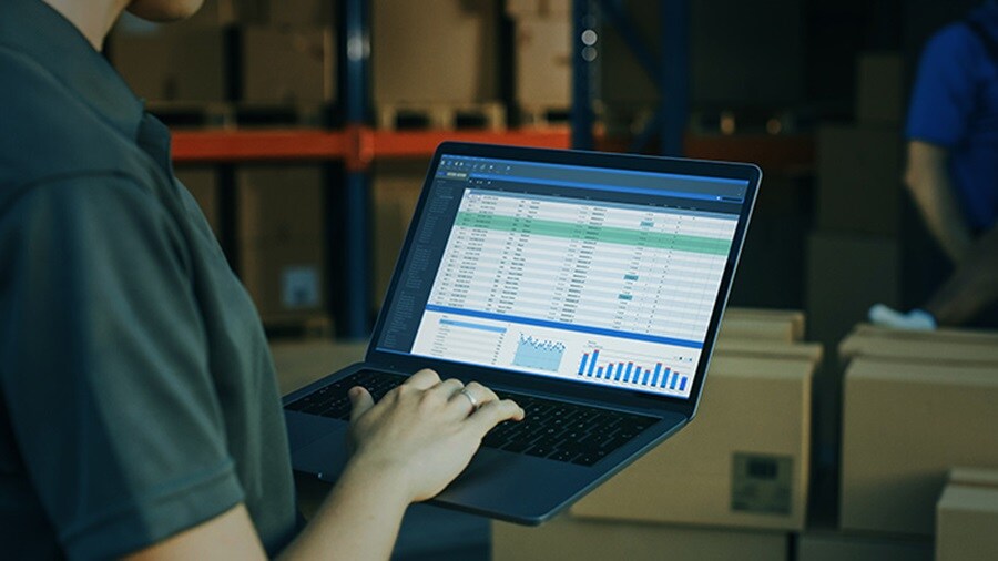 Close-up of a hand on a laptop which is showcasing real-time cargo information.