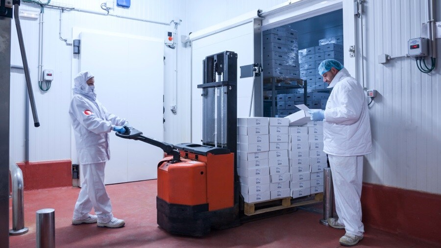 Two male in protective suit heading into cold storage