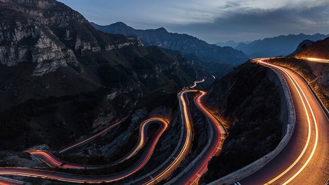Winding roads with fluorescent streaks.