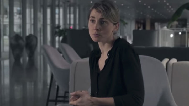 Woman with black shirt speaking on an armchair