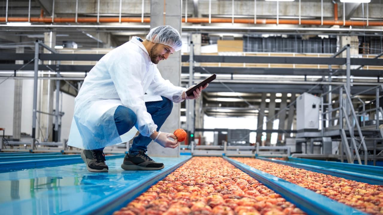 Male holding an apple wearing a lab coat