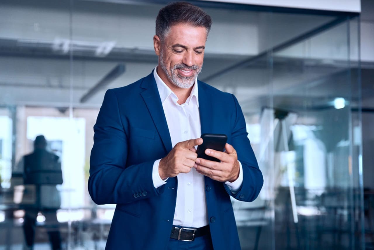 Male smiling while using his phone