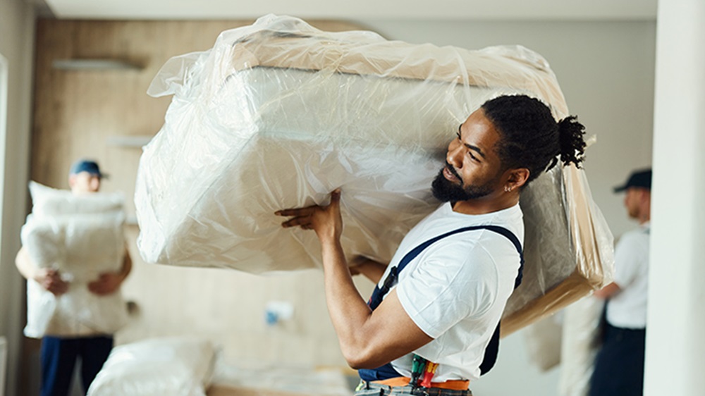 young black mover carrying furniture 