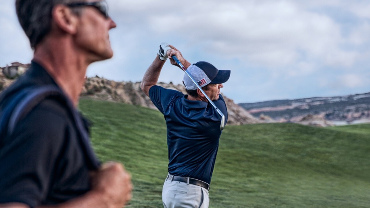 A golfer preparing to swing on a green golf course
