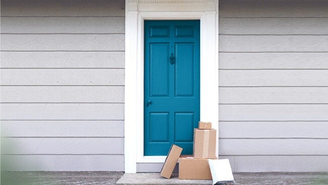A blue door with multiple packages left outside