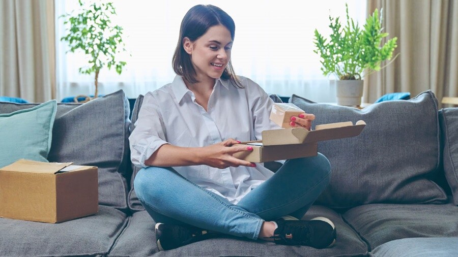 Smiling face of a female opening a box