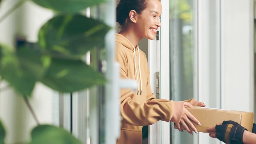 Female smiling while receiving a delivery of a shipment