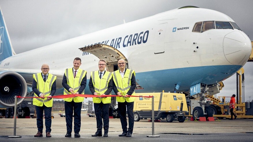 Ribbon cutting in front of plane