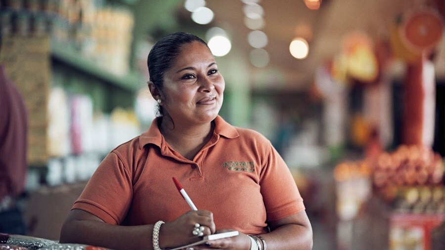 Smiling woman having pen and notepad