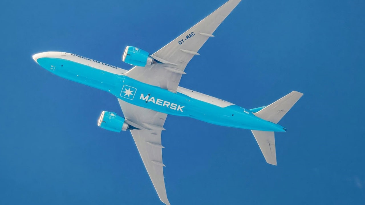 A large blue aircraft gliding through the sky on a sunny day