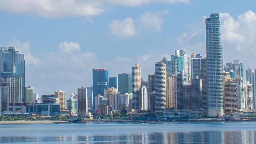 Panama City skyline with modern high-rise buildings reflected on the waterfront.