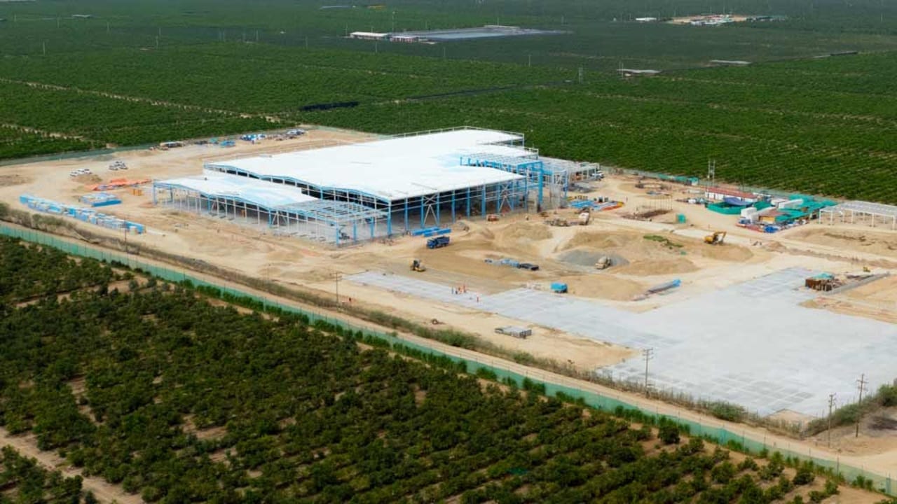 Aerial view of a large building under construction, showcasing scaffolding and machinery on the site.