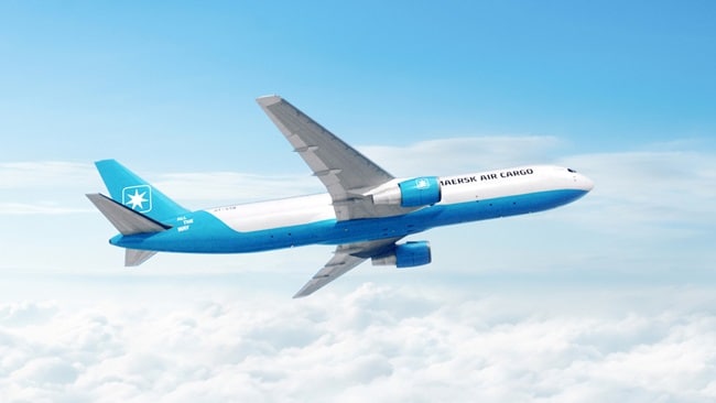 A blue and white airplane soaring through a clear blue sky.
