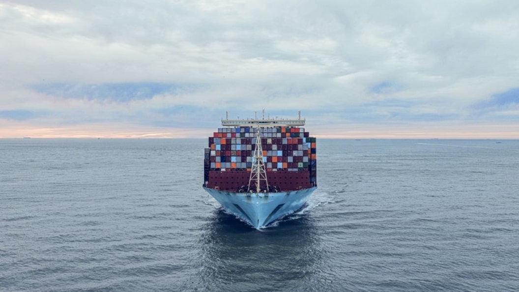 Large container ship sailing across the ocean carrying stacked shipping containers, representing global trade and ocean freight logistics.