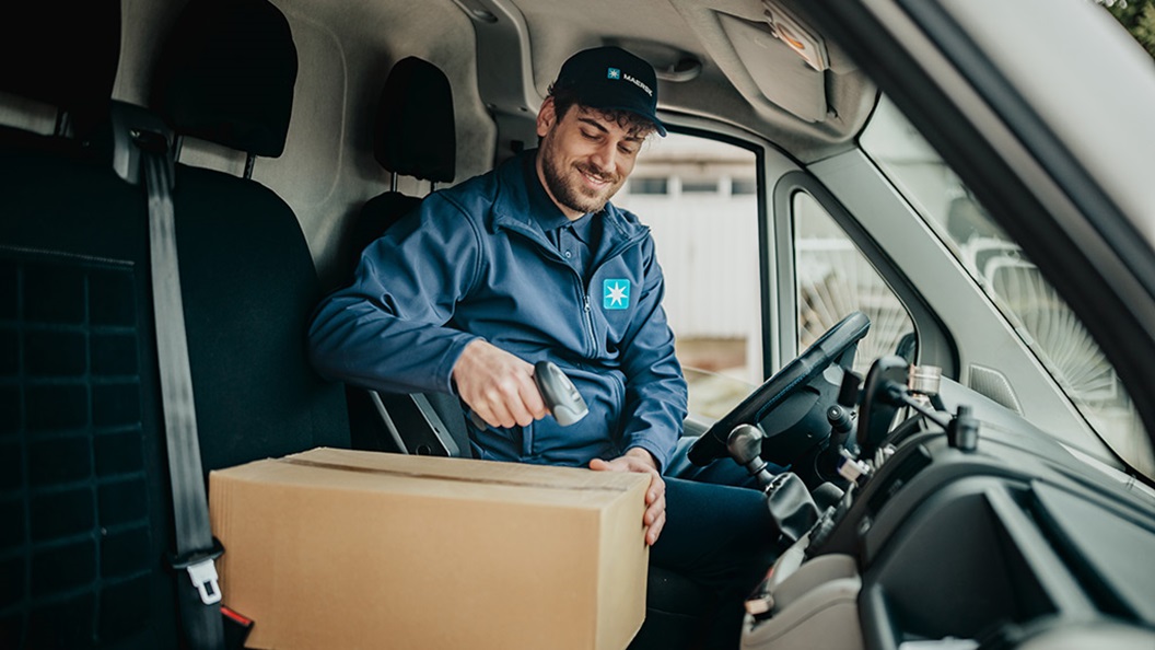 Delivery worker scans a package inside a delivery van for Maersk