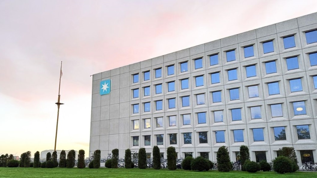 Exterior view of Maersk headquarters at Esplanaden in Copenhagen, with the Maersk star logo on the building facade and landscaped grounds in front.