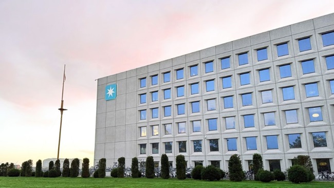 Exterior view of Maersk headquarters at Esplanaden in Copenhagen, with the Maersk star logo on the building facade and landscaped grounds in front.