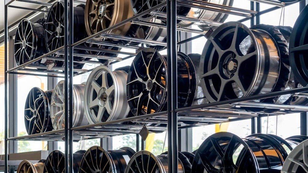 A display rack filled with various car wheels showcasing different styles and sizes.