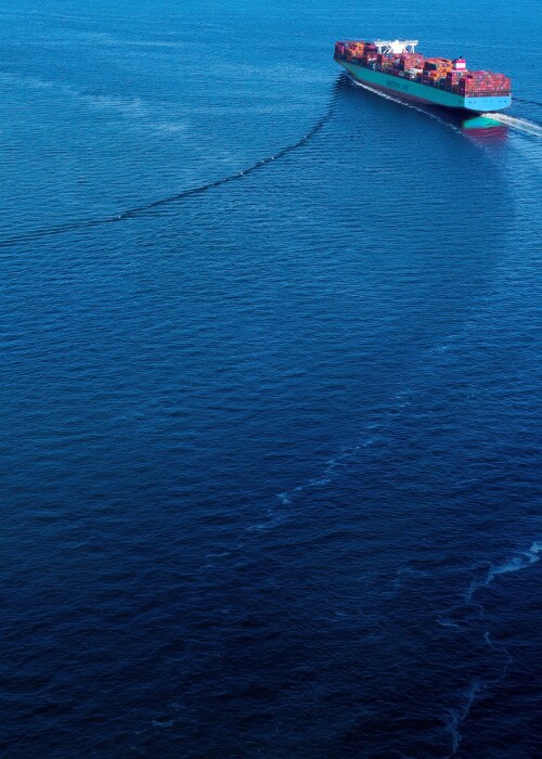 Maersk container ship sailing across the ocean with cargo