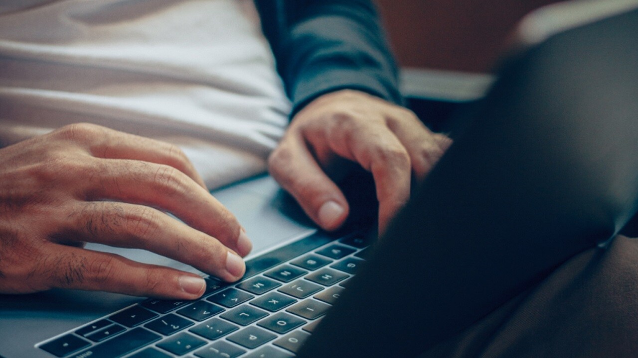 A set of hands using a laptop
